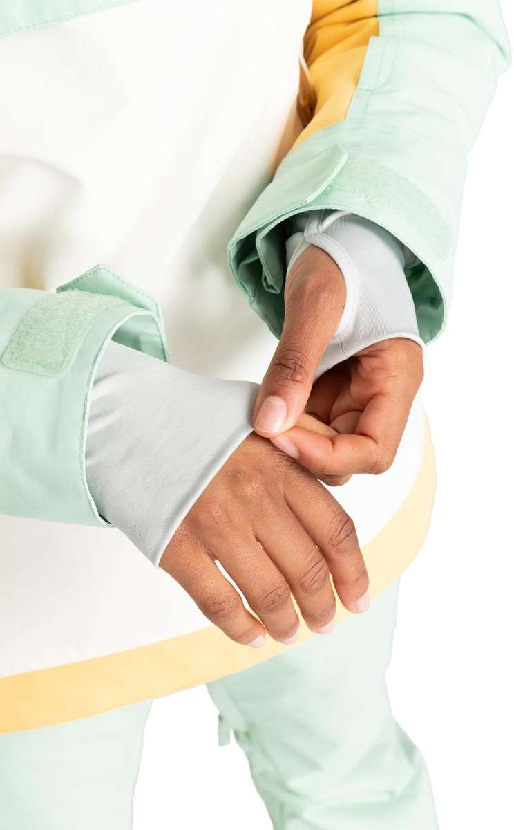 Roxy Women's Shelter Insulated Jacket 2024 - A woman wearing a mint green jacket with yellow stripe down the side, adjusting her wrist cuff.