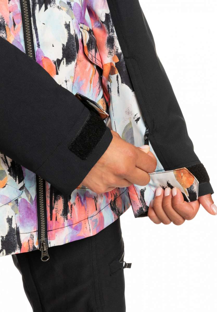 Roxy Women's Stated Insulated Jacket 2023 - A woman wearing a multicolored abstract patterned jacket with black accents and a zipper down the front.