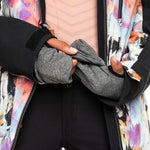 Roxy Women's Stated Insulated Jacket - A woman wearing a black jacket with a pink and purple abstract floral pattern on the back, holding it open to show the interior lining.