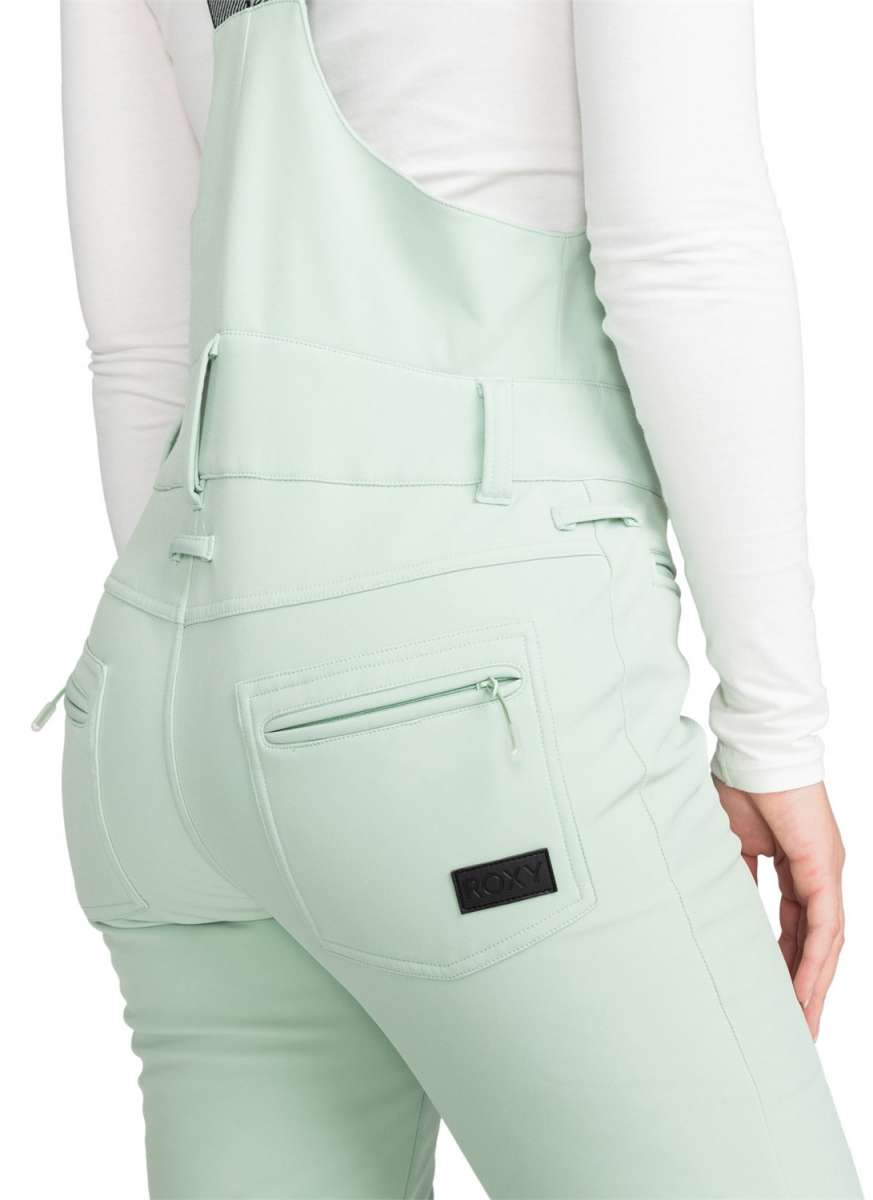 Roxy Women's Summit Bib Shell Pants 2024 - A pair of mint green snow pants with a black logo on the left thigh and adjustable straps at the waist.