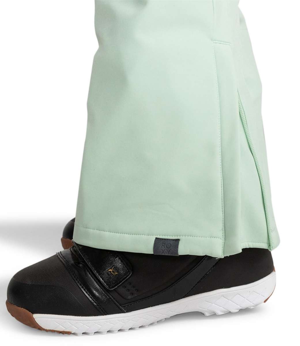 Roxy Women's Summit Bib Shell Pants 2024 - Light green bib shell pants with a black logo on the left leg and a zipper at the ankle.
