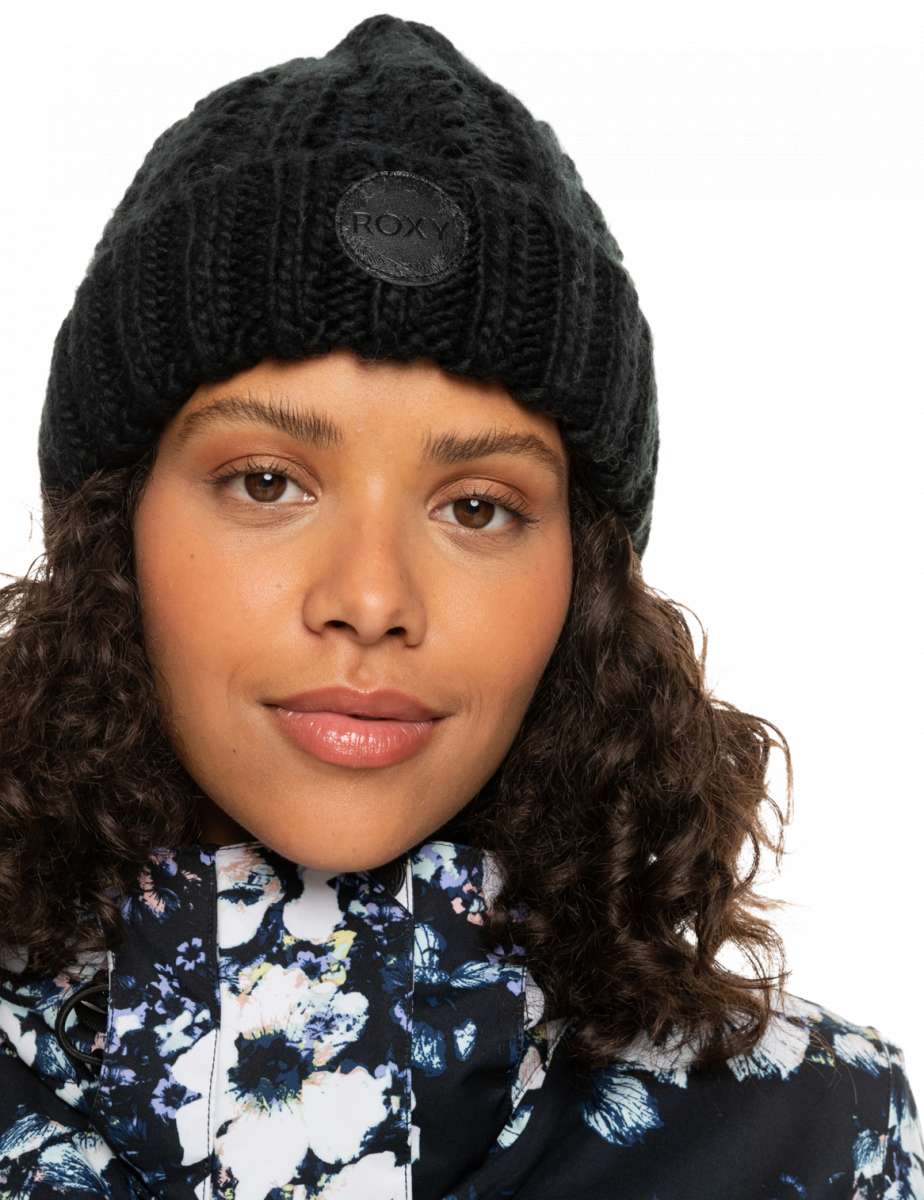 Roxy Women's Tram Beanie 2023 - A black beanie with a circular patch on the front that says "ROXY" in white letters.