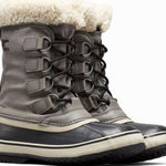 Sorel Ladies Winter Carnival Boot 2022-2023 - A pair of tall, dark brown boots with a thick cream-colored fur trim around the top and laces.