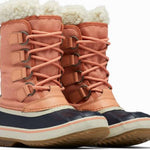 Sorel Ladies Winter Carnival Boot 2022-2023 - A pair of tall, salmon-colored boots with a thick cream-colored fur lining at the top and a black sole.