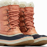 Sorel Ladies Winter Carnival Boot 2022-2023 - A pair of tall, salmon-colored boots with a thick cream-colored fur lining at the top and a black sole.