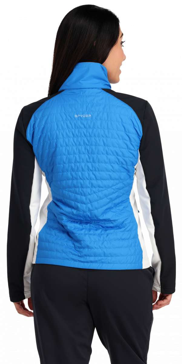 Spyder Ladies Glissade Hybrid Insulated Jacket 2023 - A blue jacket with a high collar and white accents on the sides, worn by a model facing away from the camera.