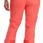 Spyder Ladies Hope Insulated Pant 2023 - A pair of coral-colored snow pants with a white stripe down the side and two zippered pockets on the back.
