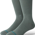 Stance Icon Crew Sock 2024 - A pair of gray crew socks with a small circular logo on the top of one sock's shin area.