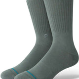 Stance Icon Crew Sock 2024 - A pair of gray crew socks with a small circular logo on the top of one sock's shin area.