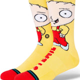 Stance Stewie Crew Sock 2024 - A pair of crew socks featuring an image of Stewie Griffin from Family Guy in a red outfit on a yellow background.