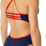 TYR Ladies' Hexa Trinityfit Swimsuit - A navy blue swimsuit with a geometric pattern on the front and back, featuring red straps that crisscross over the back.
