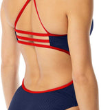 TYR Ladies' Hexa Trinityfit Swimsuit - A navy blue swimsuit with a geometric pattern on the front and back, featuring red straps that crisscross over the back.