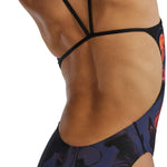 TYR Women's Cutoutfit Torch Swimsuit - A black swimsuit with a cut-out design on the sides and a red torch logo on the left hip.