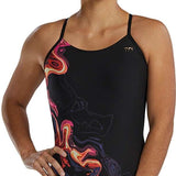 TYR Women's Cutoutfit Torch Swimsuit - A black swimsuit with a vibrant, abstract design featuring shades of orange and pink.