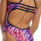 TYR Women's Trinifyfit Falcon Swimsuit - A pink and purple swimsuit with a tropical leaf pattern, featuring straps that crisscross over the back.