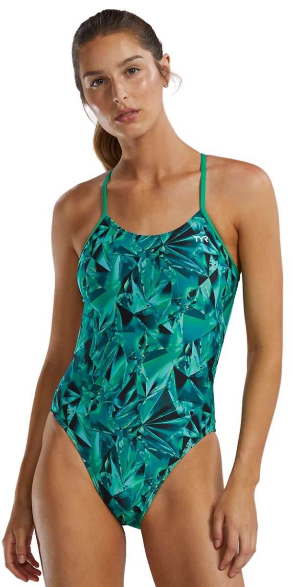 TYR Women's Crystalized Cutout Swimsuit - A woman with brown hair pulled back into a ponytail, wearing this swimsuit that features a green and blue abstract pattern of geometric shapes.