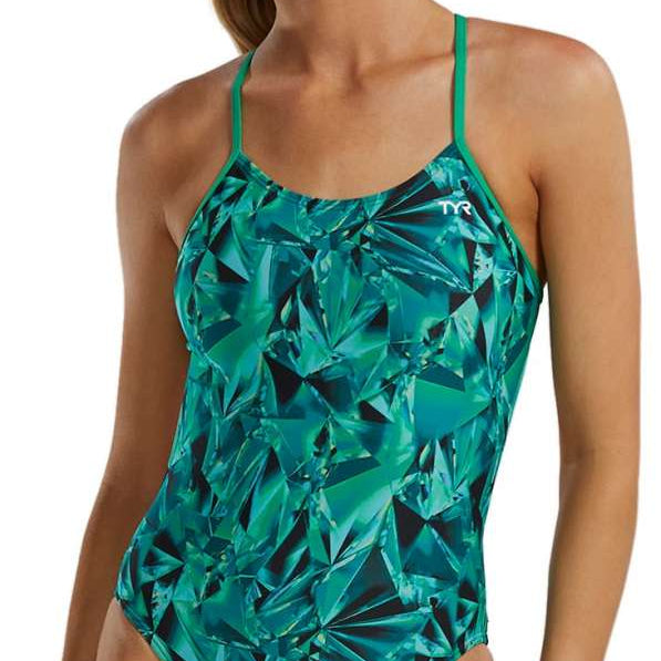 TYR Women's Crystalized Cutout Swimsuit - A woman with brown hair pulled back into a ponytail, wearing this swimsuit that features a green and blue abstract pattern of geometric shapes.