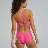 TYR Women's Lapped Trinityfit Swimsuit - A pink swimsuit with a high-cut leg and cut-out back, featuring thin straps that crisscross at the back.