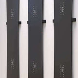 Union Snowboard Wall Mount 2023-2024 - A black metal wall mount with a minimalist design, featuring two horizontal bars and a small logo at the top.