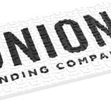 Union Surf Stomp Pad - A white surfboard pad with a repeating pattern of small, dark gray circles and lines.