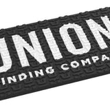 Union Surf Stomp Pad - A black surfboard pad with a white logo that reads "UNION" in large letters and "SURF STOMP PAD 2024" in smaller letters underneath.