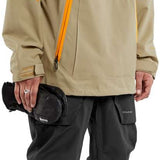 Volcom Brighton Pullover Jacket - A tan jacket with a black hood, featuring a zippered chest pocket and two side pockets.