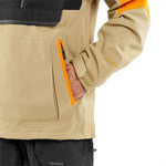 Volcom Brighton Pullover Jacket 2024 - A tan jacket with a black chest pocket and orange accents on the shoulders, collar, and zipper.
