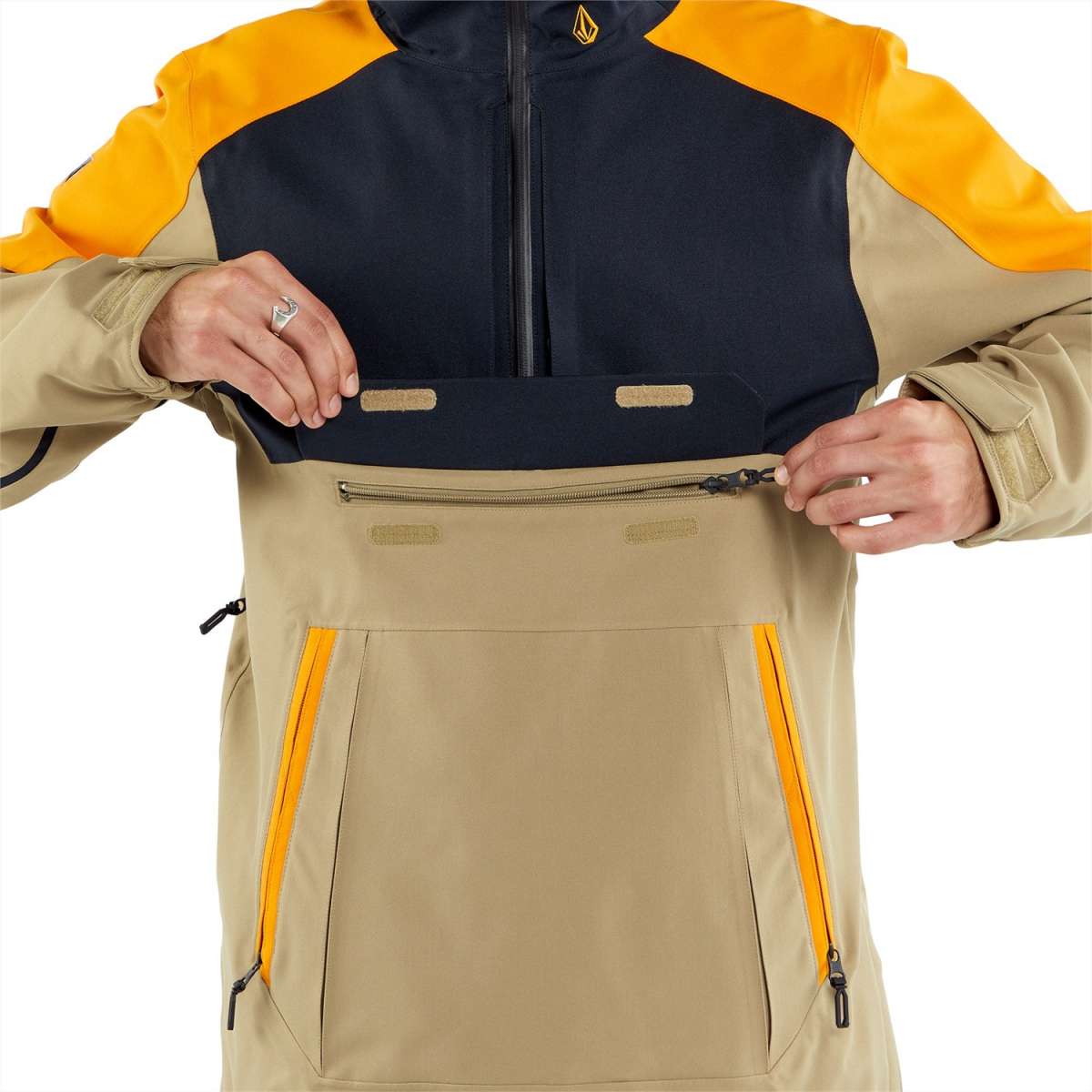 Volcom Brighton Pullover Jacket 2024 - A tan-colored jacket with a black chest panel and yellow accents on the shoulders.
