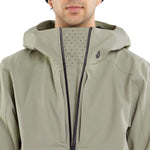 Volcom Brighton Pullover Jacket 2024 - A sage green jacket with a hood and zippered pockets, featuring a small black logo on the left chest area.