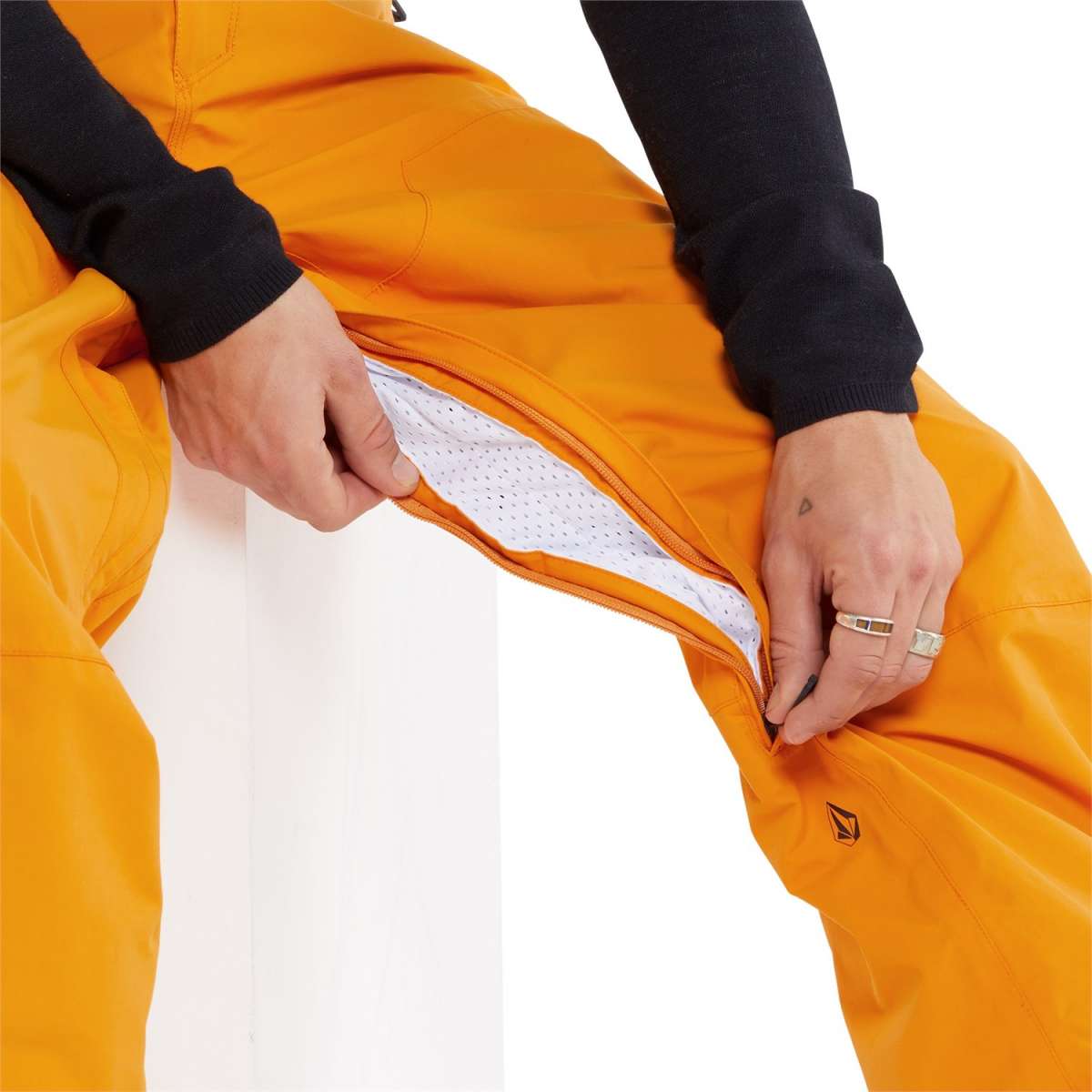 Volcom L GORE-TEX Shell Pant 2024 - A pair of orange snow pants with a zippered fly and black logo on the left leg.
