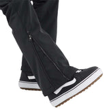 Volcom Women's Battle Stretch High Rise Pants 2024 - Black pants with a white stripe on the side, featuring a zipper and snap button closure at the ankle.