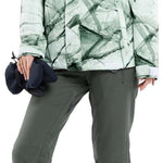 Volcom Women's Bolt Insulated Jacket - A white jacket with a green geometric pattern and a hood, worn by a model with blonde hair in braids.