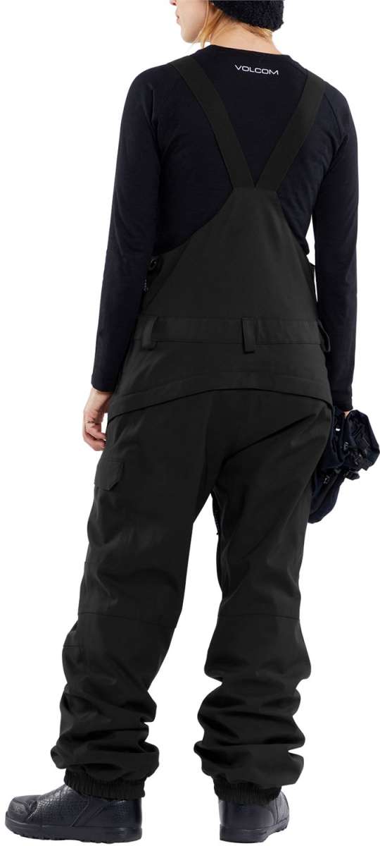 Volcom Women's Creston 3D Stretch Bib Pant - Black bib pant with white logo on left thigh and adjustable Velcro straps at waist.