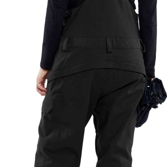 Volcom Women's Creston 3D Stretch Bib Pant - Black bib pant with white logo on left thigh and adjustable Velcro straps at waist.