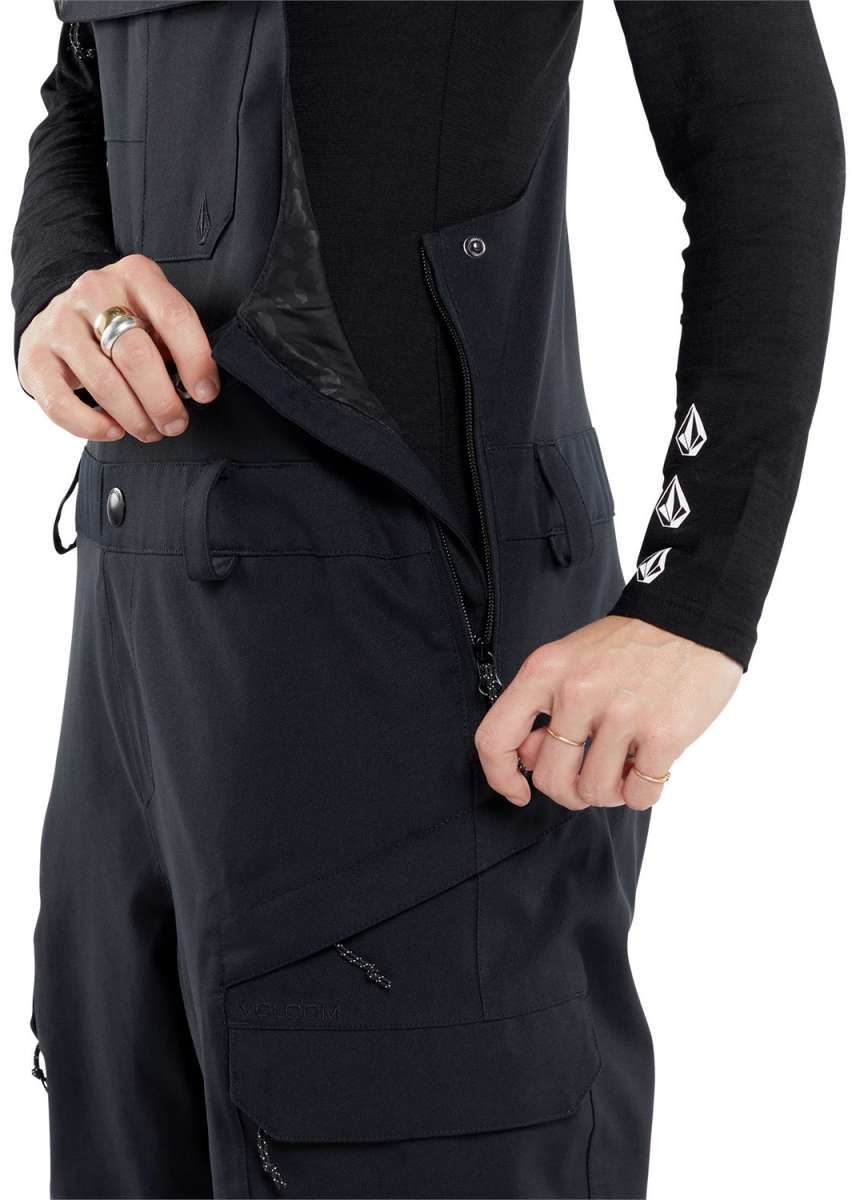 Volcom Women's Creston 3D Stretch Bib Pant - Black bib pant with diagonal white stripe pattern on left leg and black drawstring at waistband.