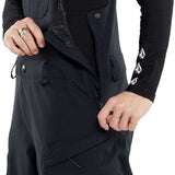 Volcom Women's Creston 3D Stretch Bib Pant - Black bib pant with diagonal white stripe pattern on left leg and black drawstring at waistband.