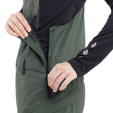 Volcom Women's Elm Stretch GORE-TEX Bib Pant 2024 - A dark green bib pant with a black zipper and logo on the left thigh.