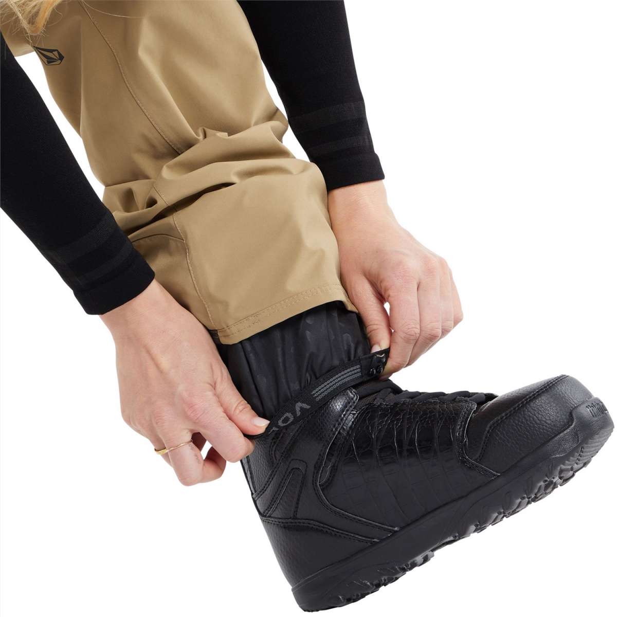 Volcom Women's Elm Stretch GORE-TEX Bib Pant - A pair of khaki-colored snow pants with a black logo on the left thigh and a black zipper pull.
