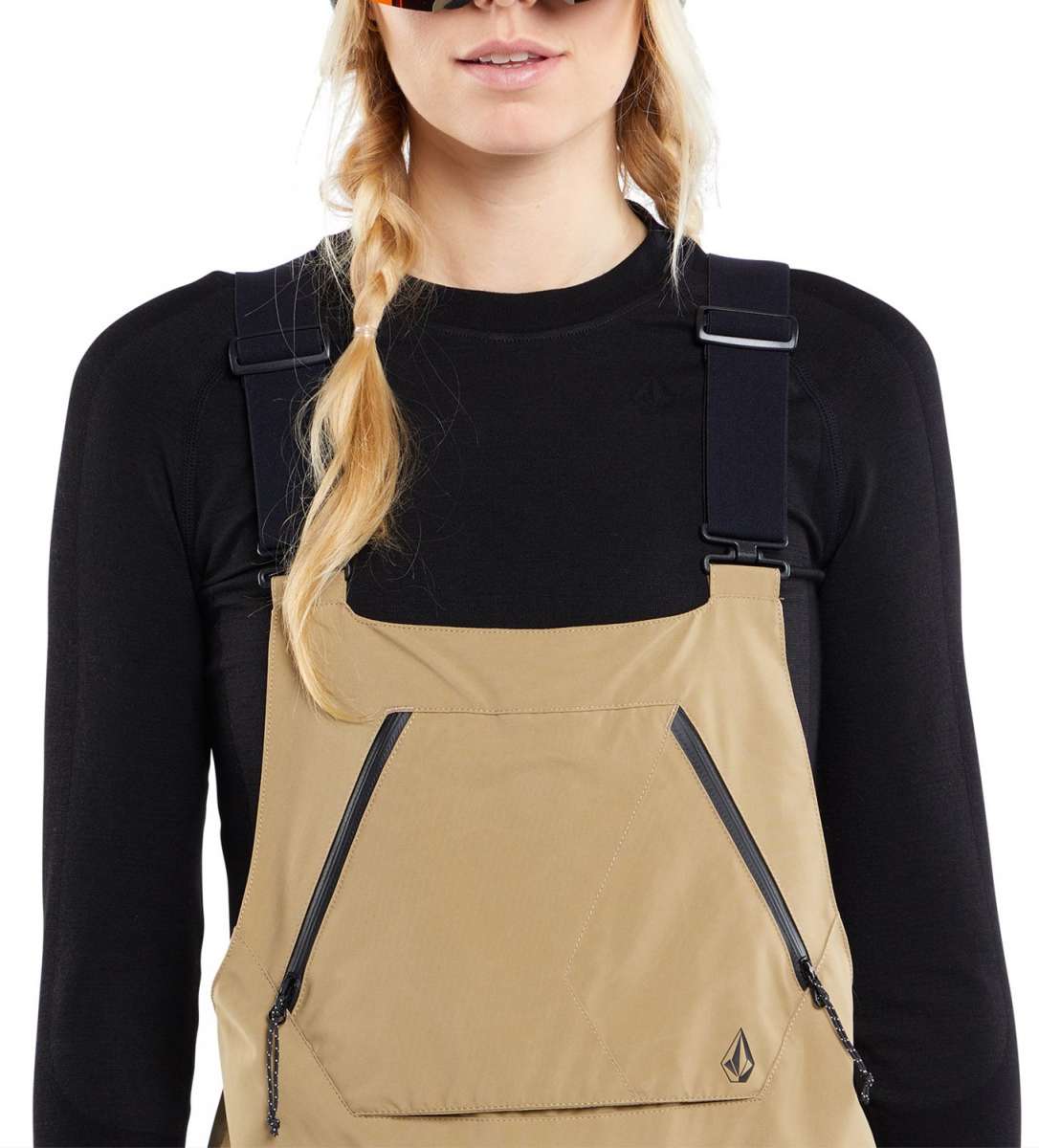 Volcom Women's Elm Stretch GORE-TEX Bib Pant - A pair of tan bib pants with a black zipper on the side and a small logo in the bottom right corner.