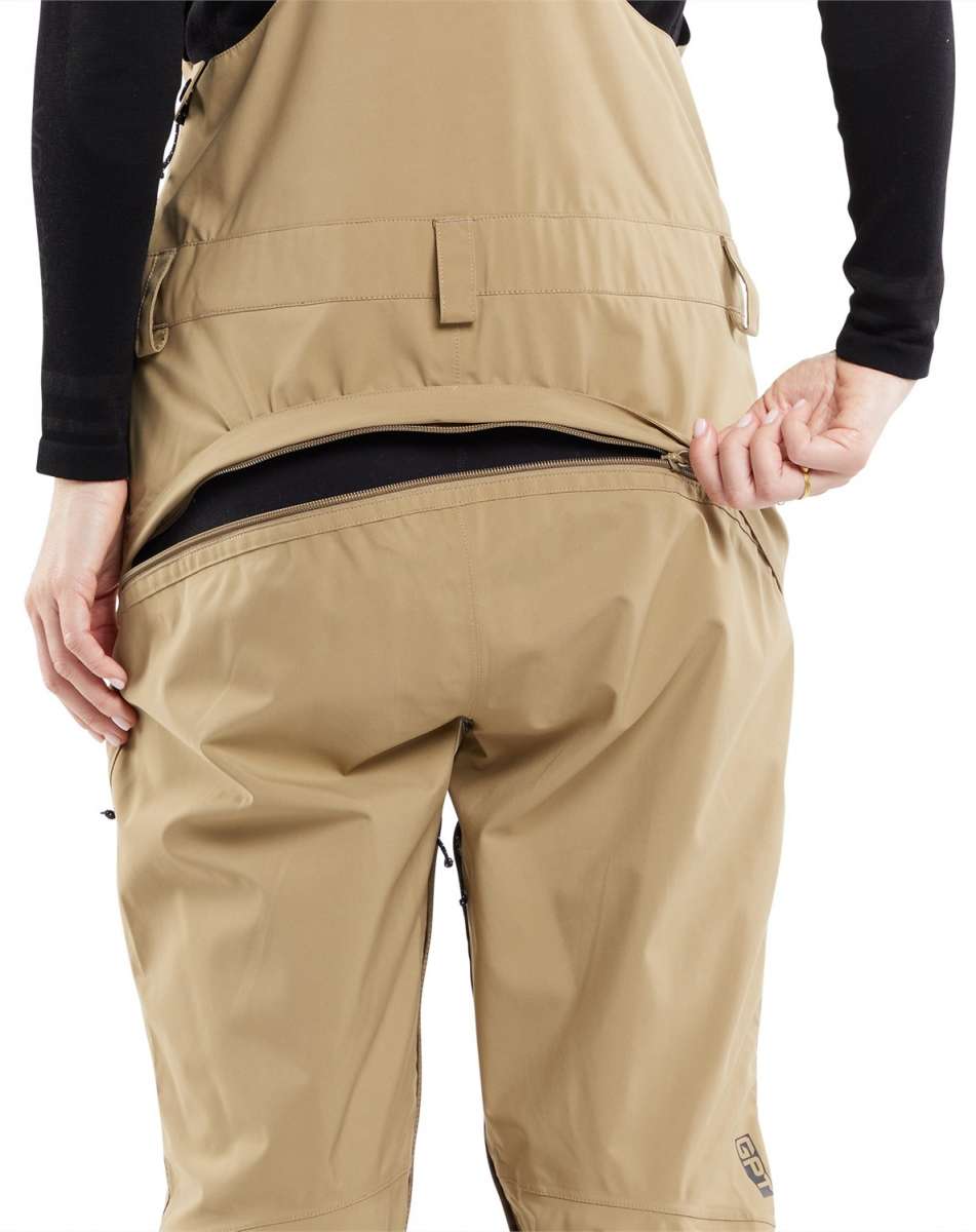 Volcom Women's Elm Stretch GORE-TEX Bib Pant 2024 - Beige bib pant with a black logo on the left thigh and adjustable Velcro straps at the waist.