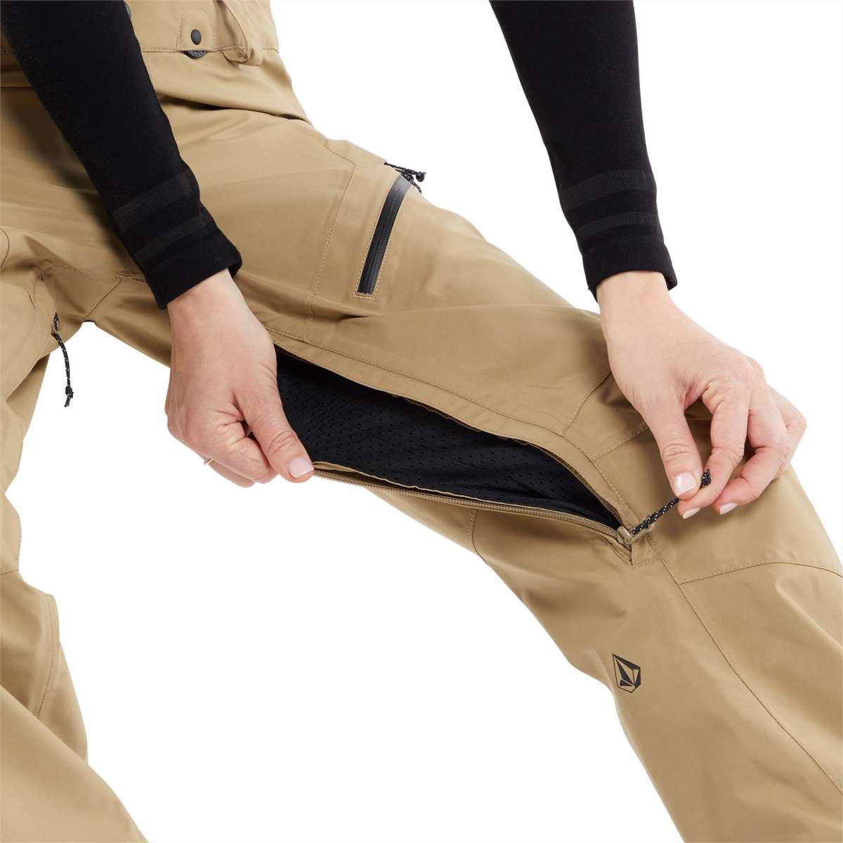 Volcom Women's Elm Stretch GORE-TEX Bib Pant - A pair of khaki-colored snow pants with a black zipper on the side pocket, featuring a stretchy material and a GORE-TEX logo.