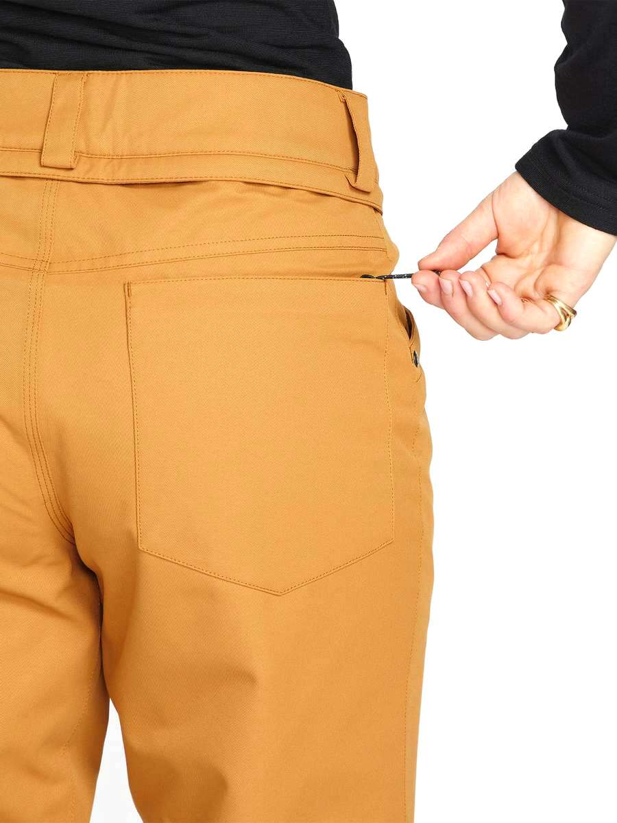Volcom Women's Hallen Shell Pant 2023 - A pair of khaki-colored snow pants with a zippered pocket on the side.