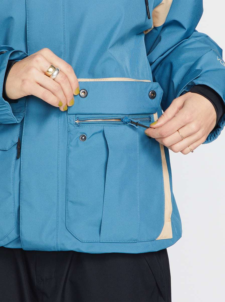 Volcom Women's Melancon GORE-TEX Jacket - A blue jacket with a tan stripe on the side, featuring a zippered chest pocket and two front pockets.