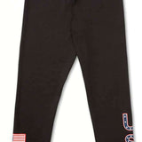 Volcom Women's USA Bottom Base - A pair of black leggings with a white outline of the United States on the left thigh and "USA" in blue letters outlined in red on the right leg.