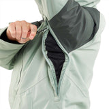 Volcom Women's V.co Aris Insulated Gore-Tex Jacket 2024 - A woman wearing a sage green jacket with black accents on the shoulders and chest, zipped up to her neck.