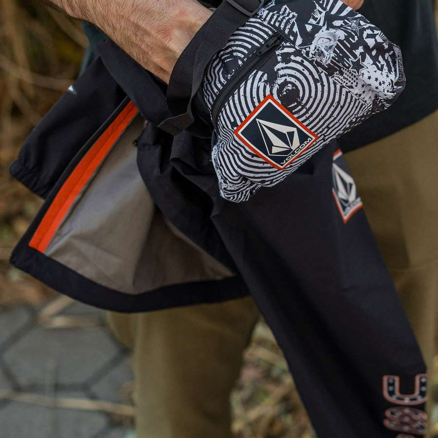 Volcom Pack It USA GORE-TEX Jacket 2022 - A black jacket with a white and red logo on the left chest, featuring a distinctive pattern of concentric circles in white and grey.