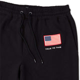 Volcom USST Iconic Stone Pants 2022 - Black pants with a small American flag patch on the left thigh.