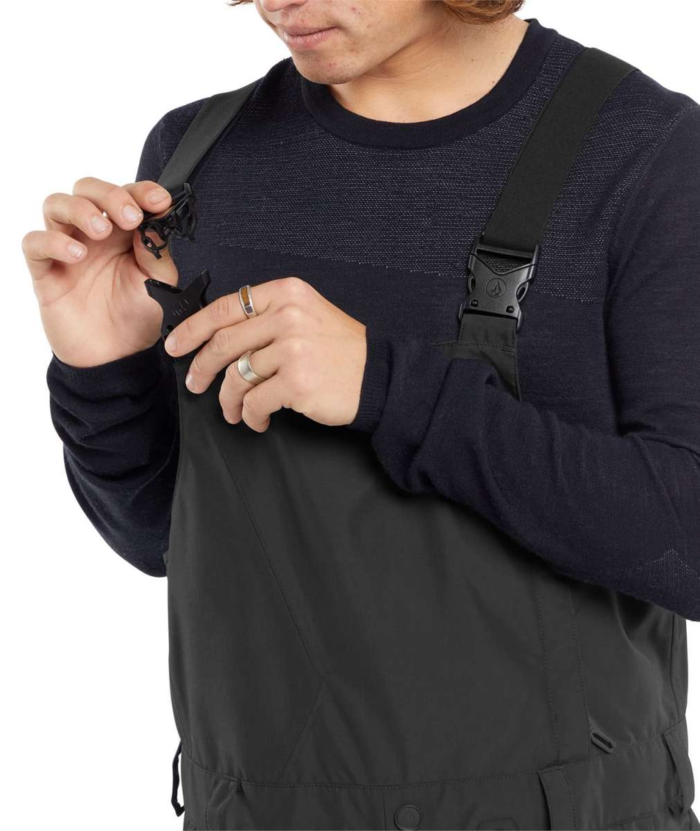 Volcom V.Co Sparta Bib Overall Pants 2024 - Black bib overalls with diagonal white stripes on the side of the leg and a black logo patch on the right thigh.