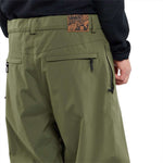Volcom X Dustbox Pant 2024 - Olive green pants with a zippered pocket on the right thigh and a small logo patch near the bottom of the left leg.