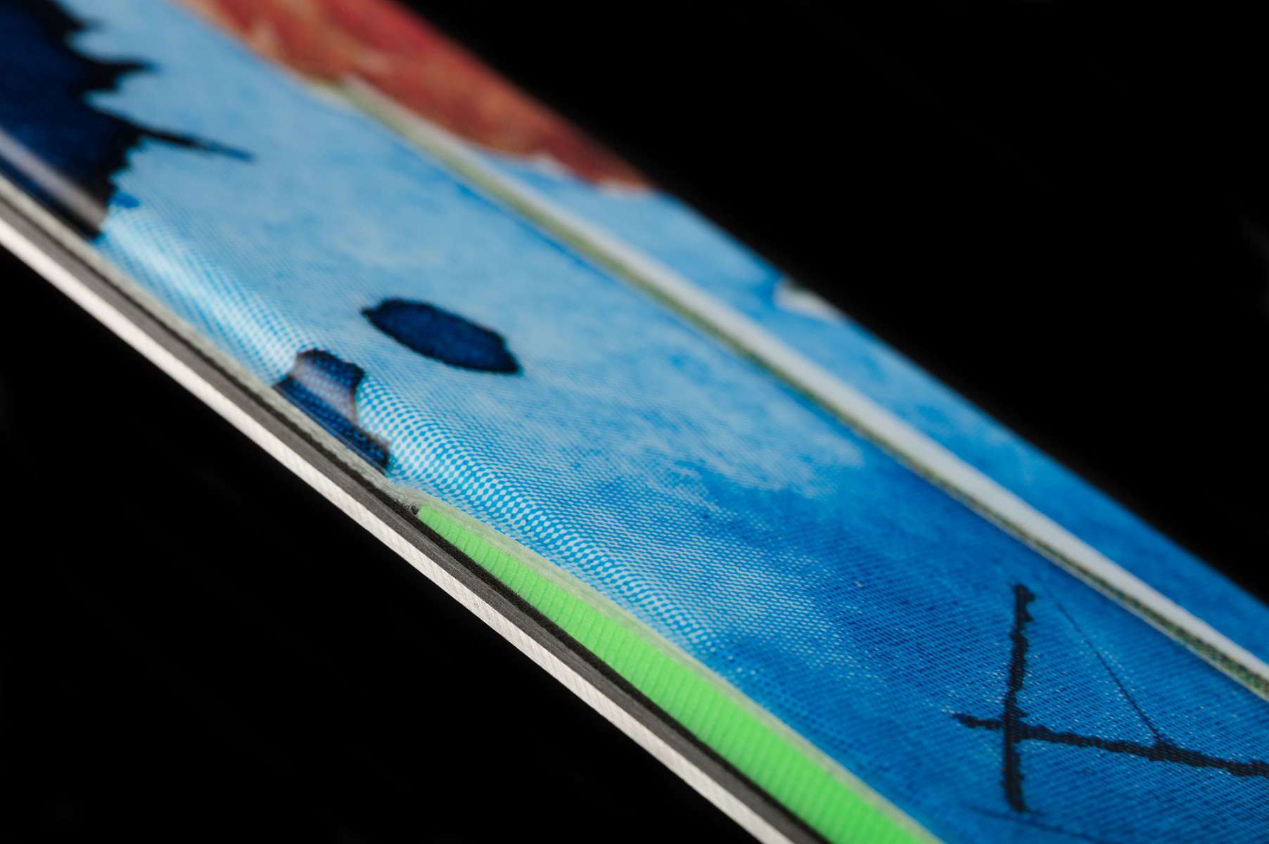 Volkl Revolt 90 Flat Ski 2022-2023 - A blue ski with a black and white checkered pattern on top, featuring a distinctive red stripe along its side.